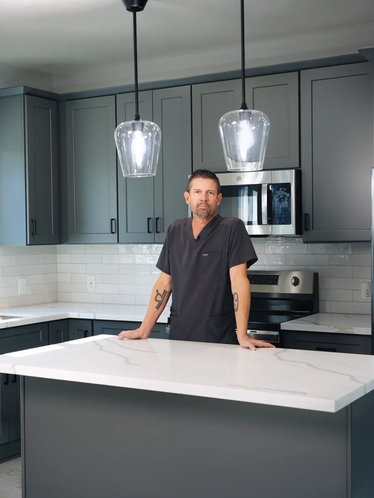 A man leaning on the counter of a finished ADU kitchen